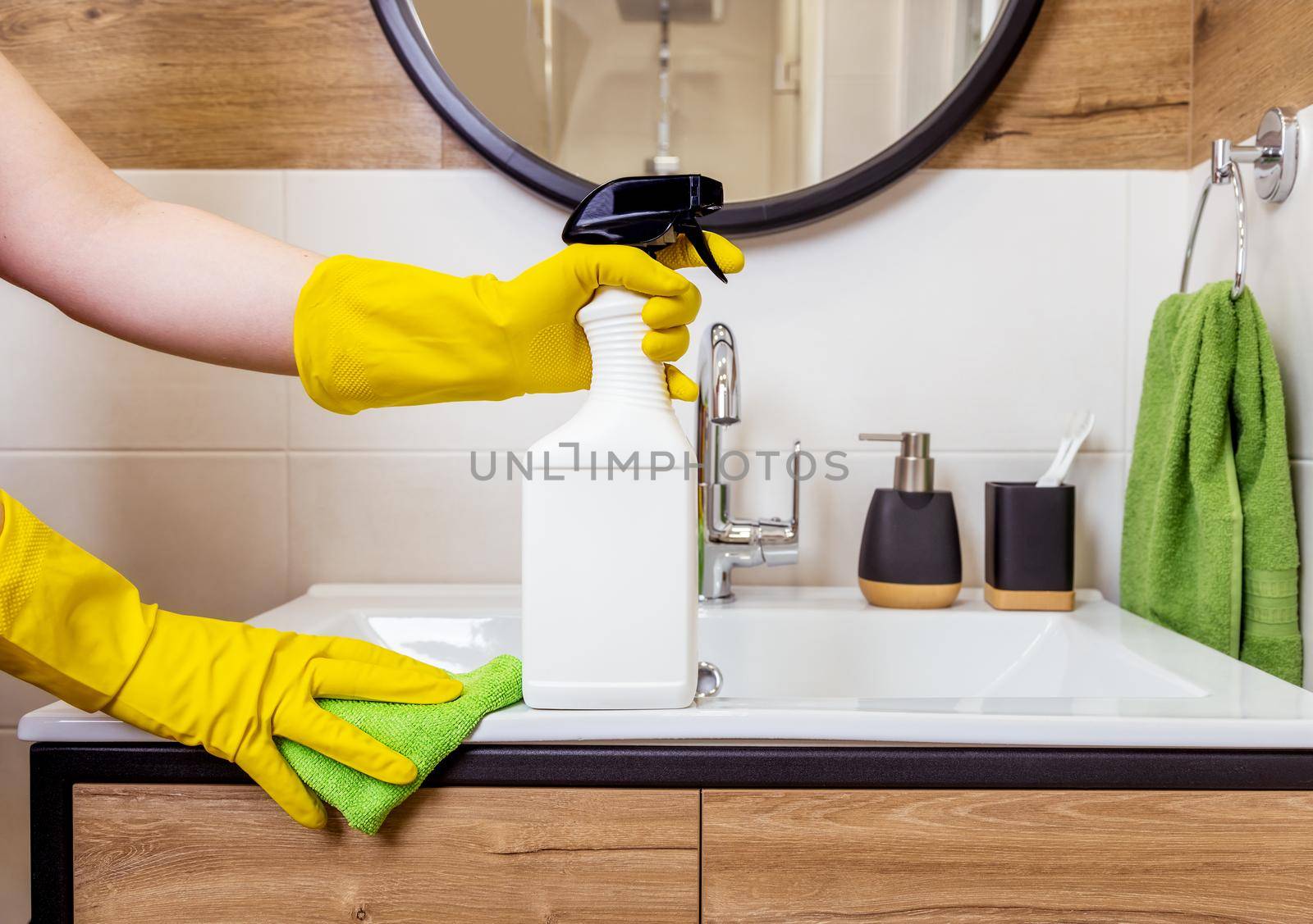 close-up of female hand in a protective glove holds white bottle. Cleaner layout by Ramanouskaya
