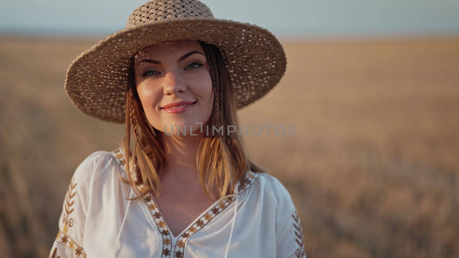 Portrait of ukrainian woman in wheat field after harvesting. Attractive cheerful lady in embroidery vyshyvanka blouse and straw hat. Ukraine, independence, freedom, patriot symbol, charming girl.