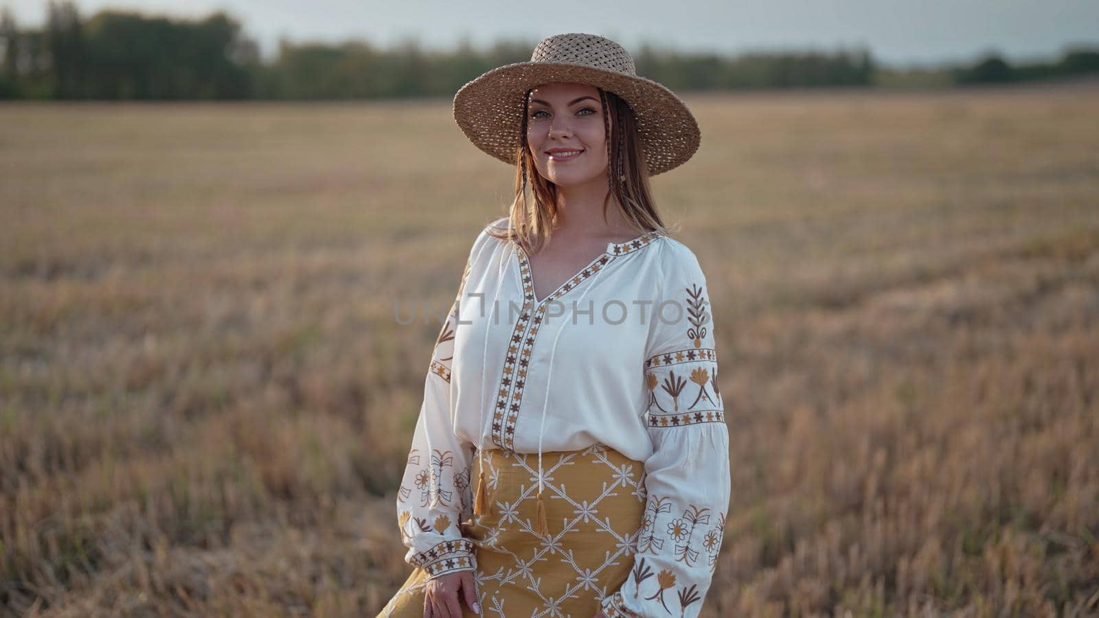 Portrait of ukrainian woman in wheat field after harvesting. Attractive cheerful lady in embroidery vyshyvanka blouse and straw hat. Ukraine, independence, freedom, patriot symbol, charming girl by kristina_kokhanova