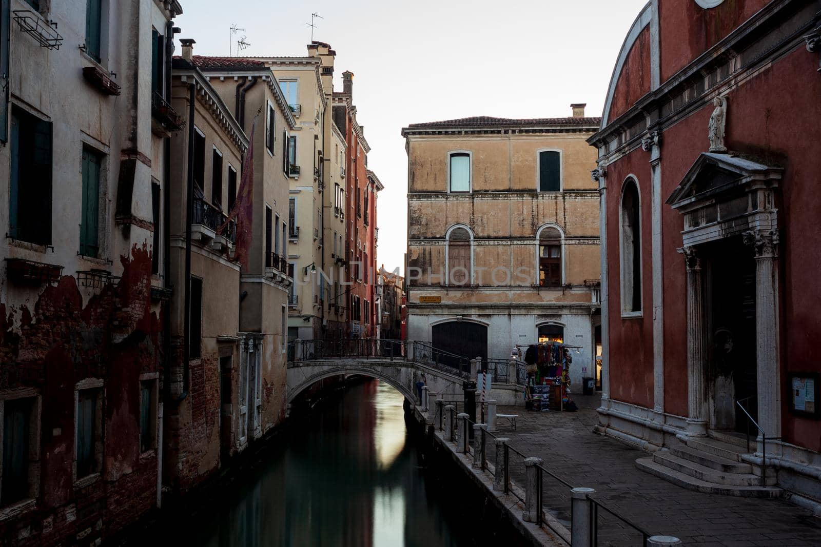 The old bridge made with marble on the typical canal in Venice by bepsimage