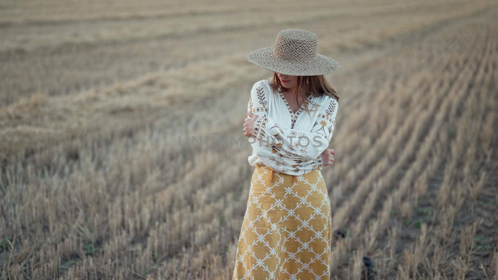 Ukrainian woman in traditional ethnic costume and straw hat in wheat field. Attractive stylish lady in vyshyvanka. Stylish modern girl, Ukraine, independence, freedom, patriot by kristina_kokhanova