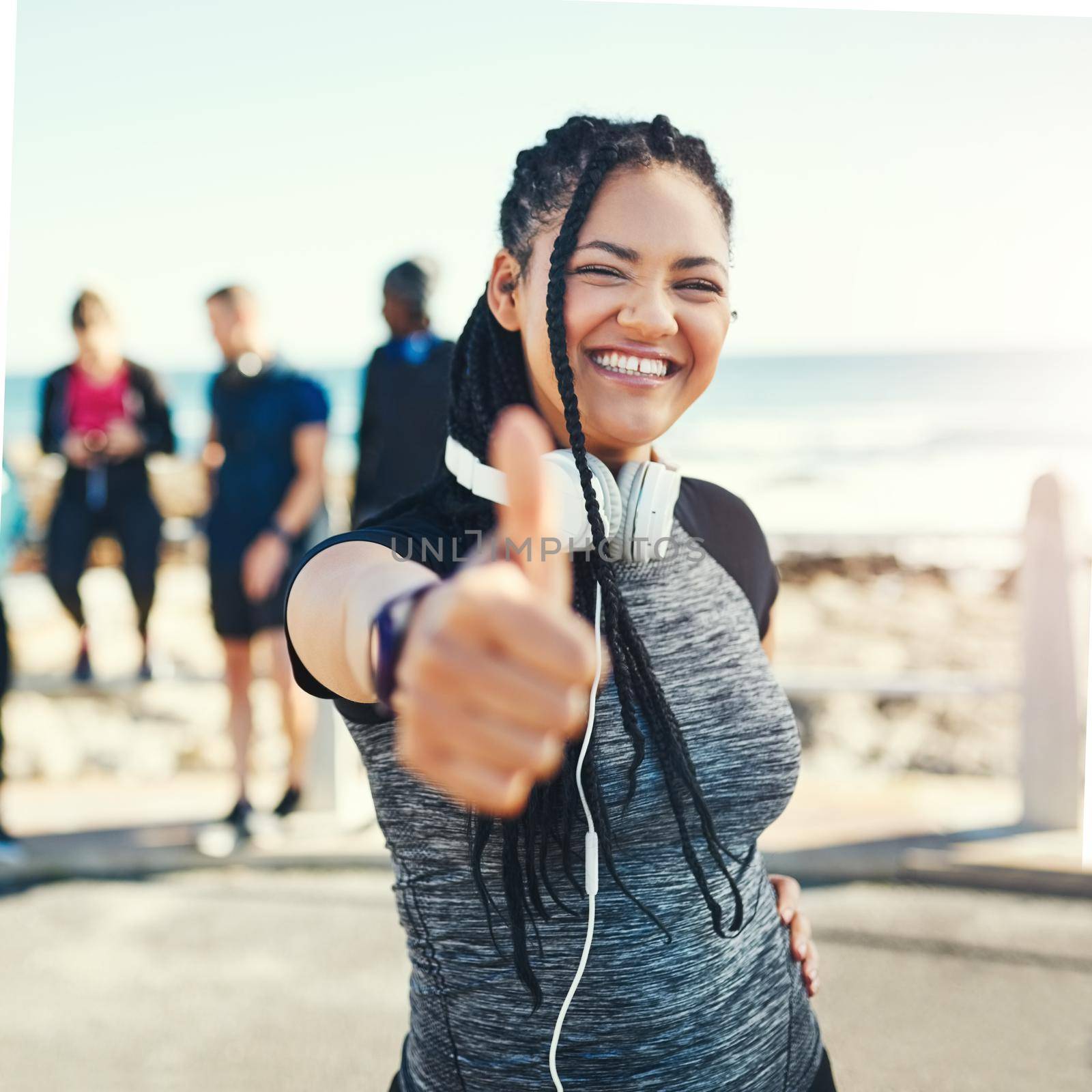 Youre well on your way to a better you. Portrait of a sporty young woman showing thumbs up while exercising outdoors. by YuriArcurs