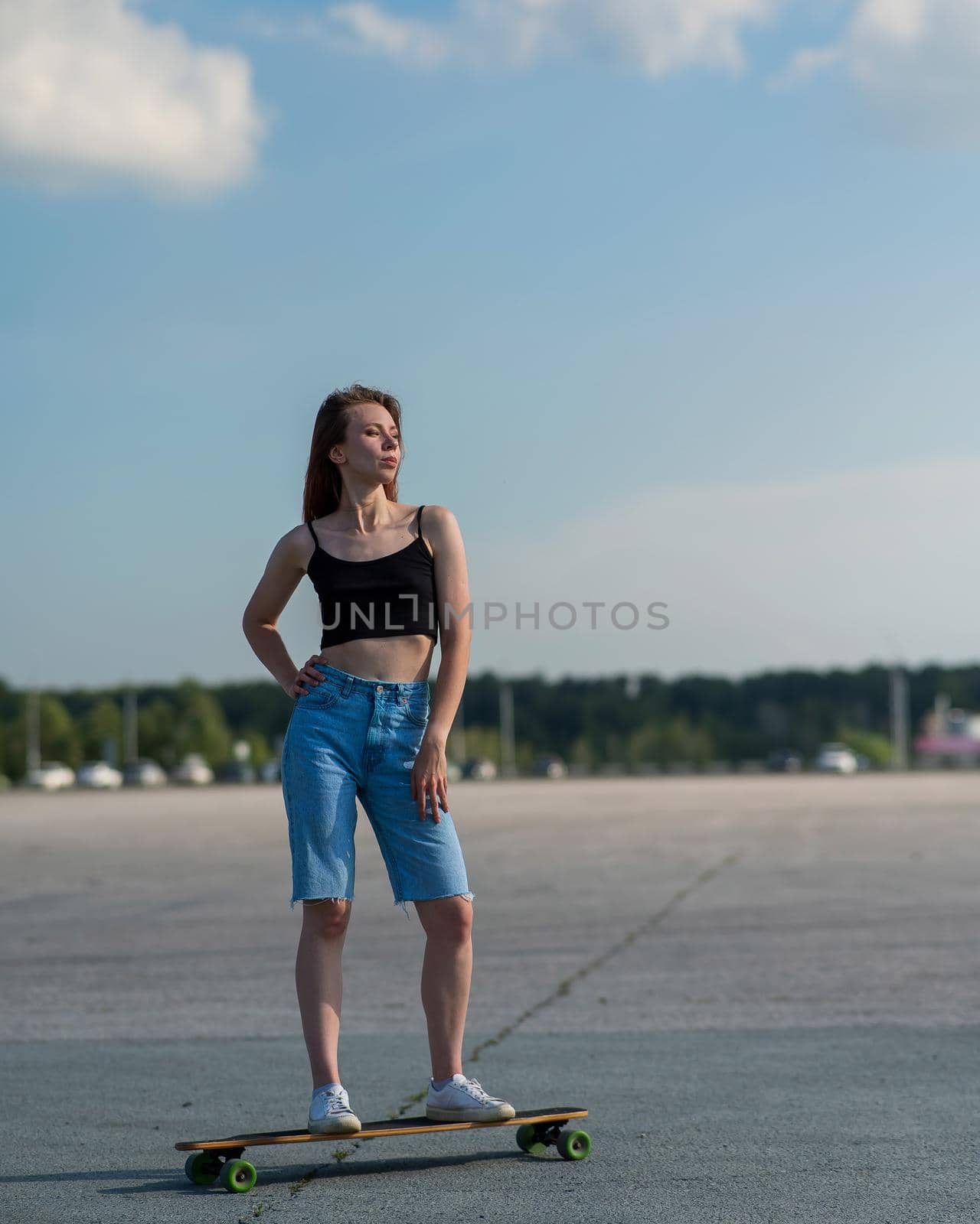 Young caucasian woman riding a longboard outdoors. by mrwed54