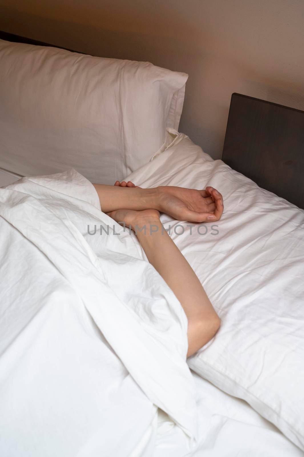 Woman sleeping in the bed under white sheet.