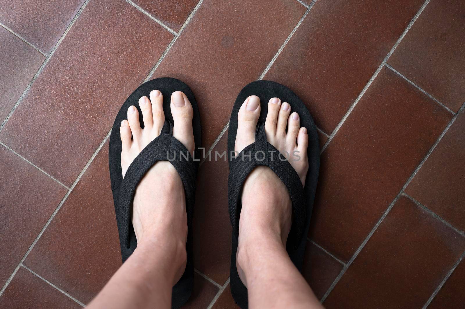 Feet of woman with bigger flip flops slippers by SimmiSimons