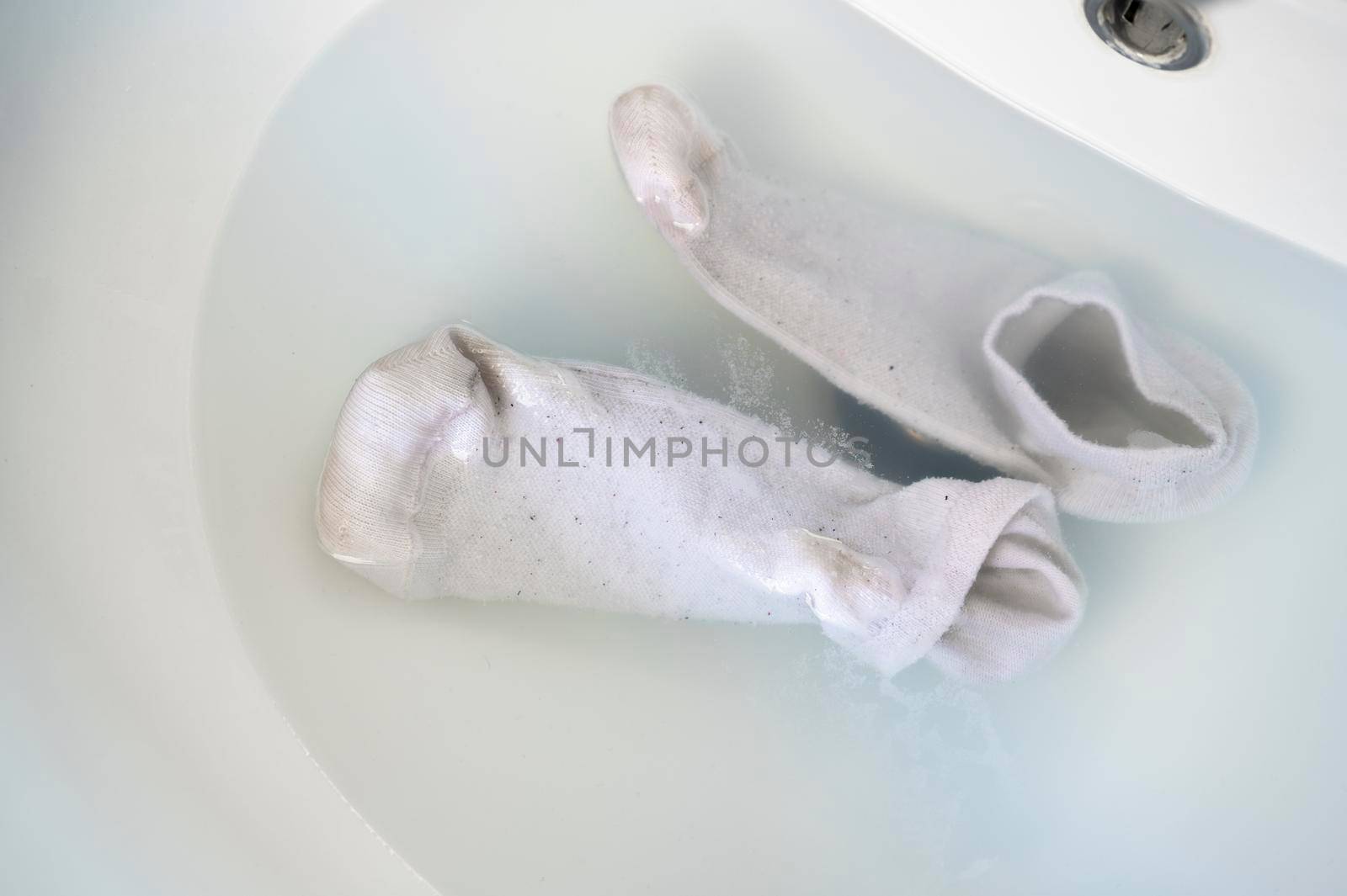 Cleaning dirty socks in the sink water by SimmiSimons