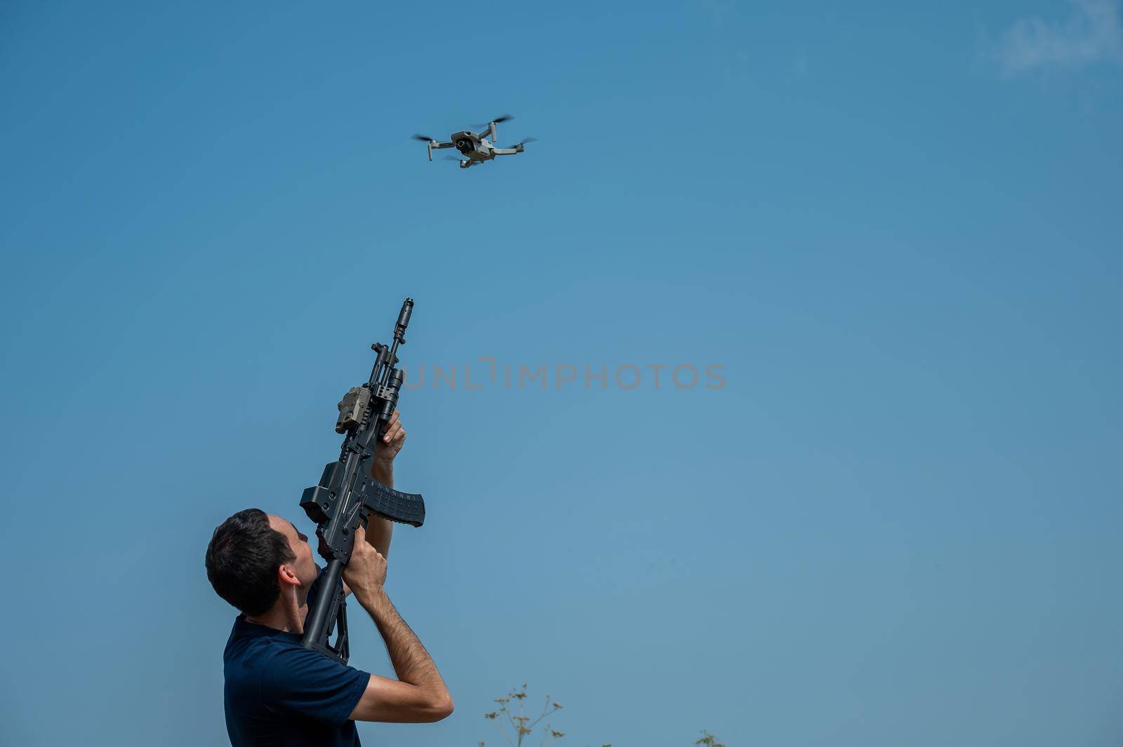 Caucasian man shoots a flying drone with a rifle