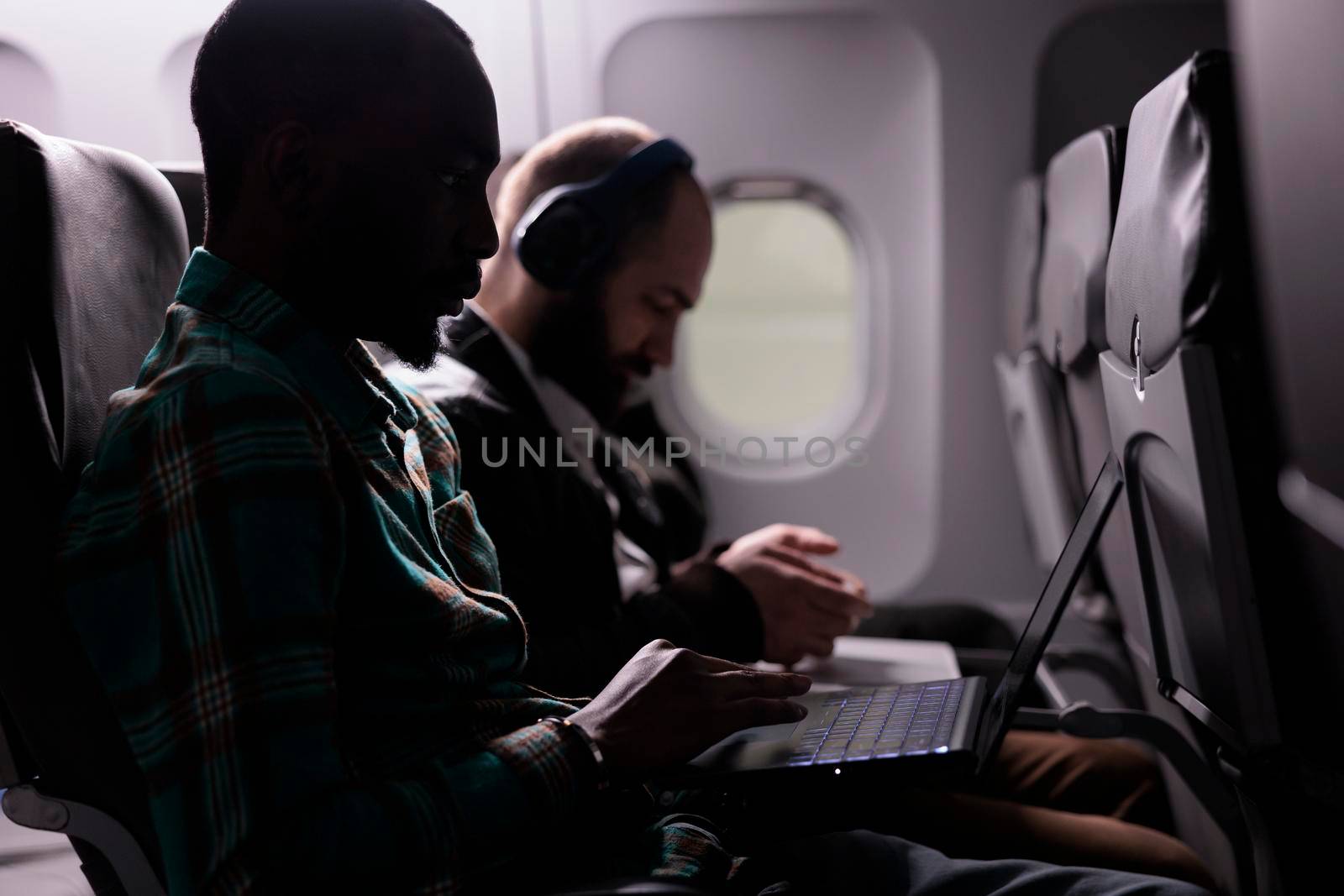 Multiethnic group of people travelling abroad by airplane, flying with international airline in economy class. Going on holiday vacation or business trip with plane tarnsportation service.