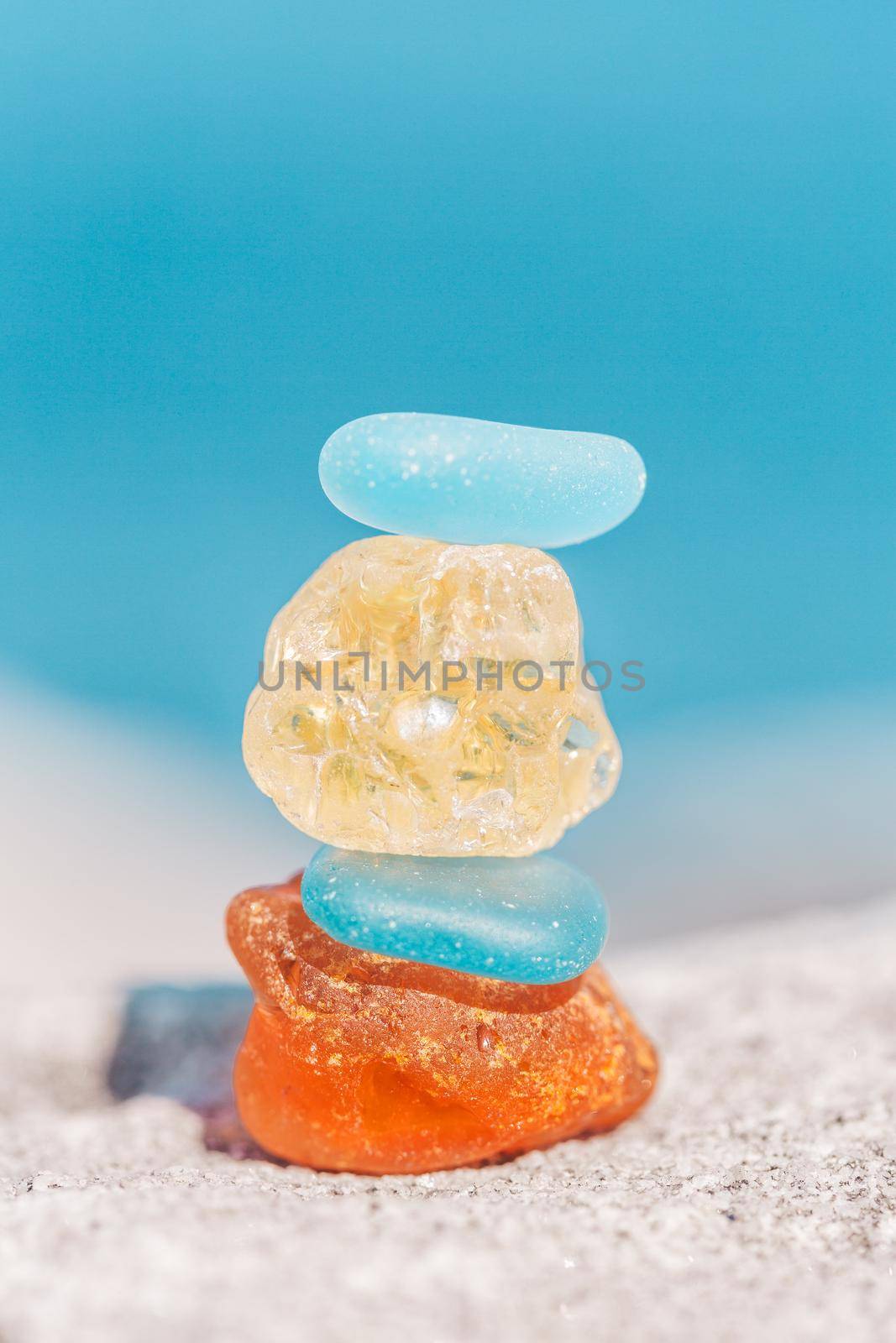 Macro shot of zen sea glass stone balance stack by the ocean. The act of balancing stones carries with it a practice of patience and a physical effort of creating balance and calm