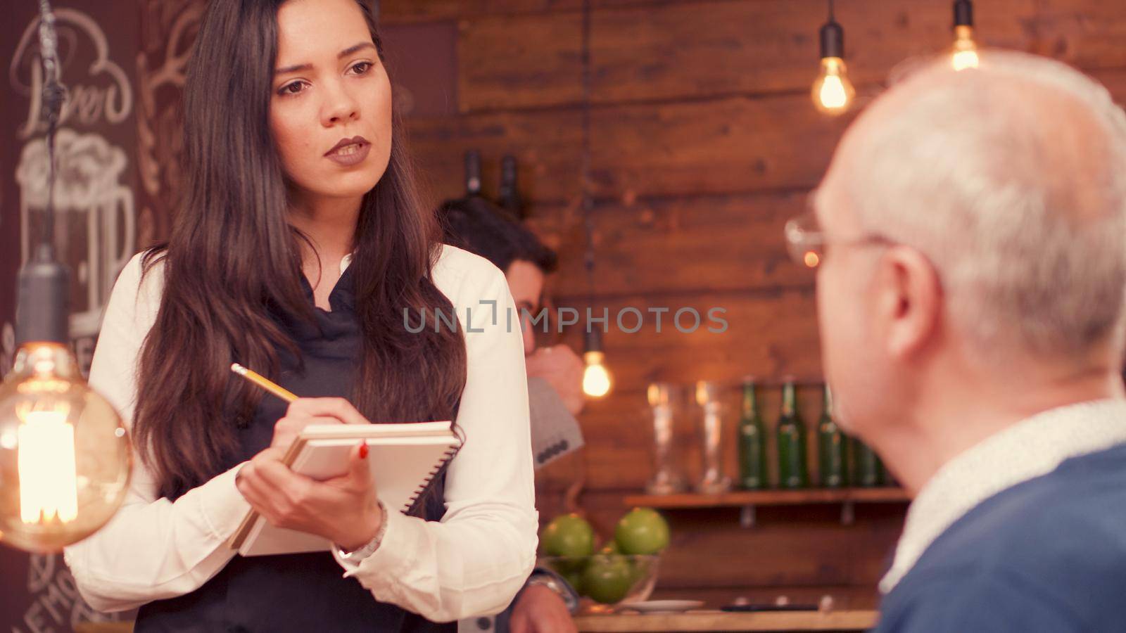 Senior man talking with the waiter in a restaurant. Relaxed man. Man in his sixties.