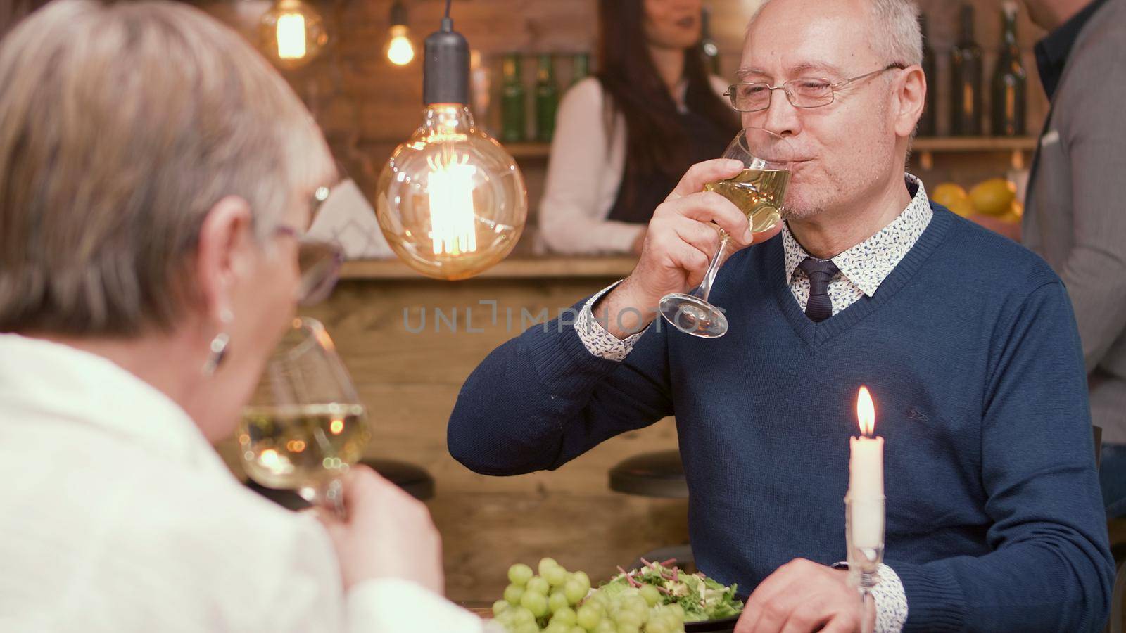 Couple in their sixties drinking wine while they are in a restaurant to eat lunch. Romantic couple. Senior couple.