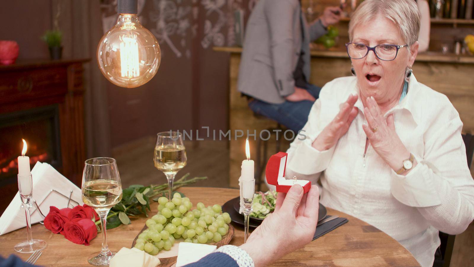Old woman looking schocked at the ring that her husband gave. Asking her to marry him.