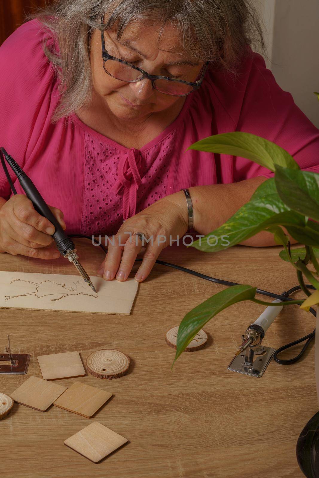 woman drawing with a pyrograph by joseantona