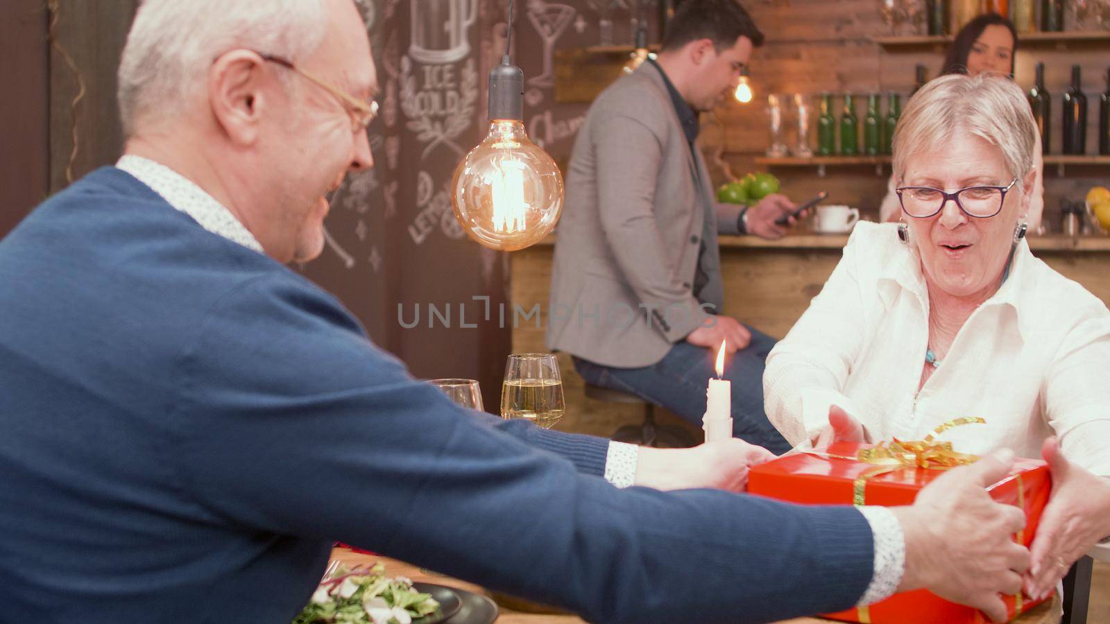 Couple in their sixties feeling good in a restaurant by DCStudio