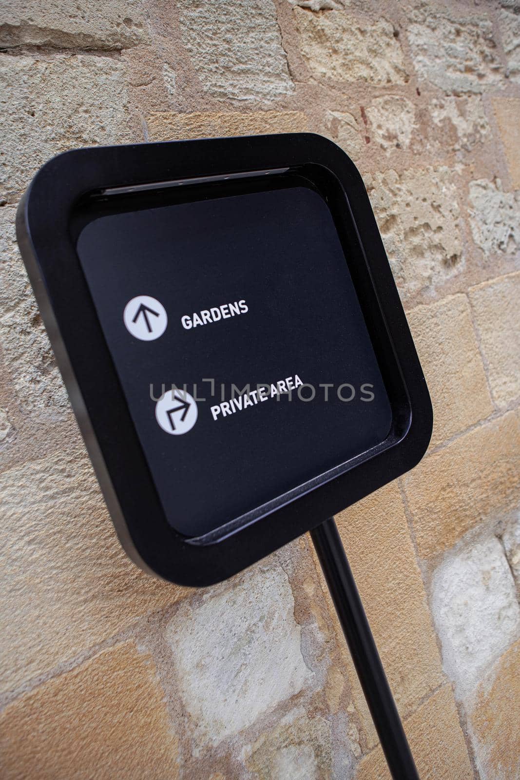 Arrows on a sign and stone wall on background