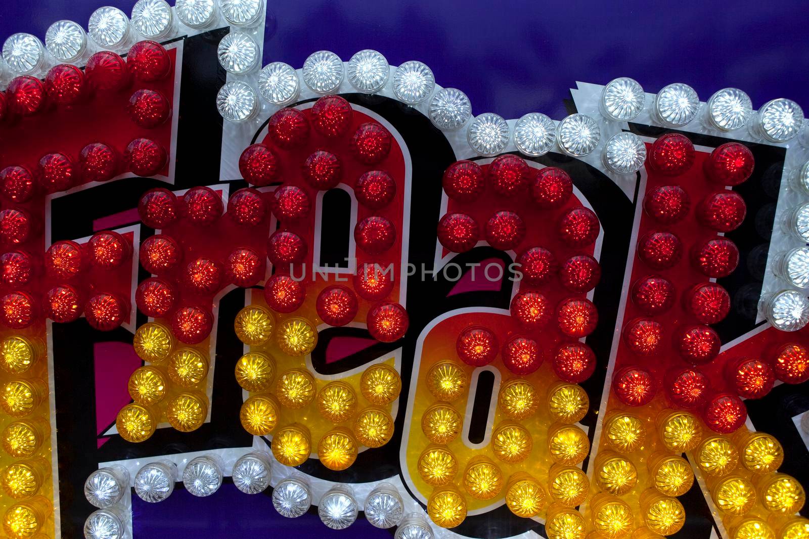 Close up of neon sign and bulbs on a ride in a fairground