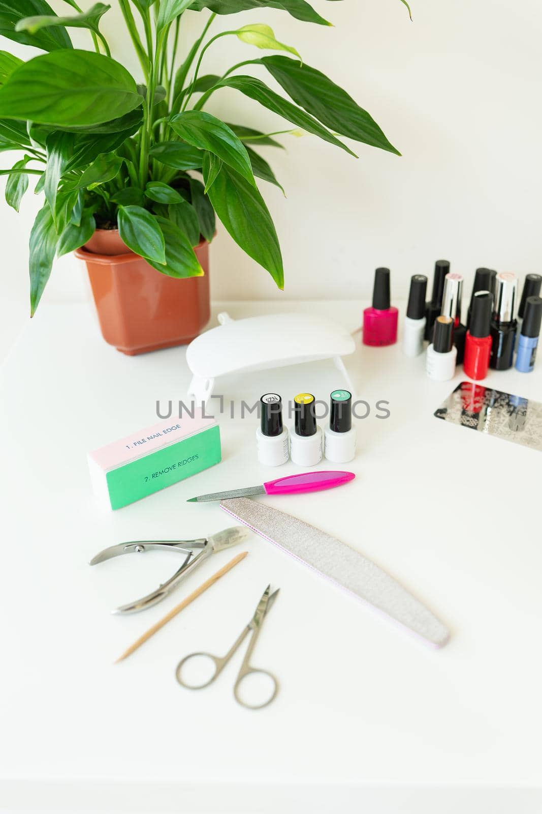 The concept of the workspace of the master of the nail salon. Top view of manicure tools on a white table. Cosmetic procedures and hand care