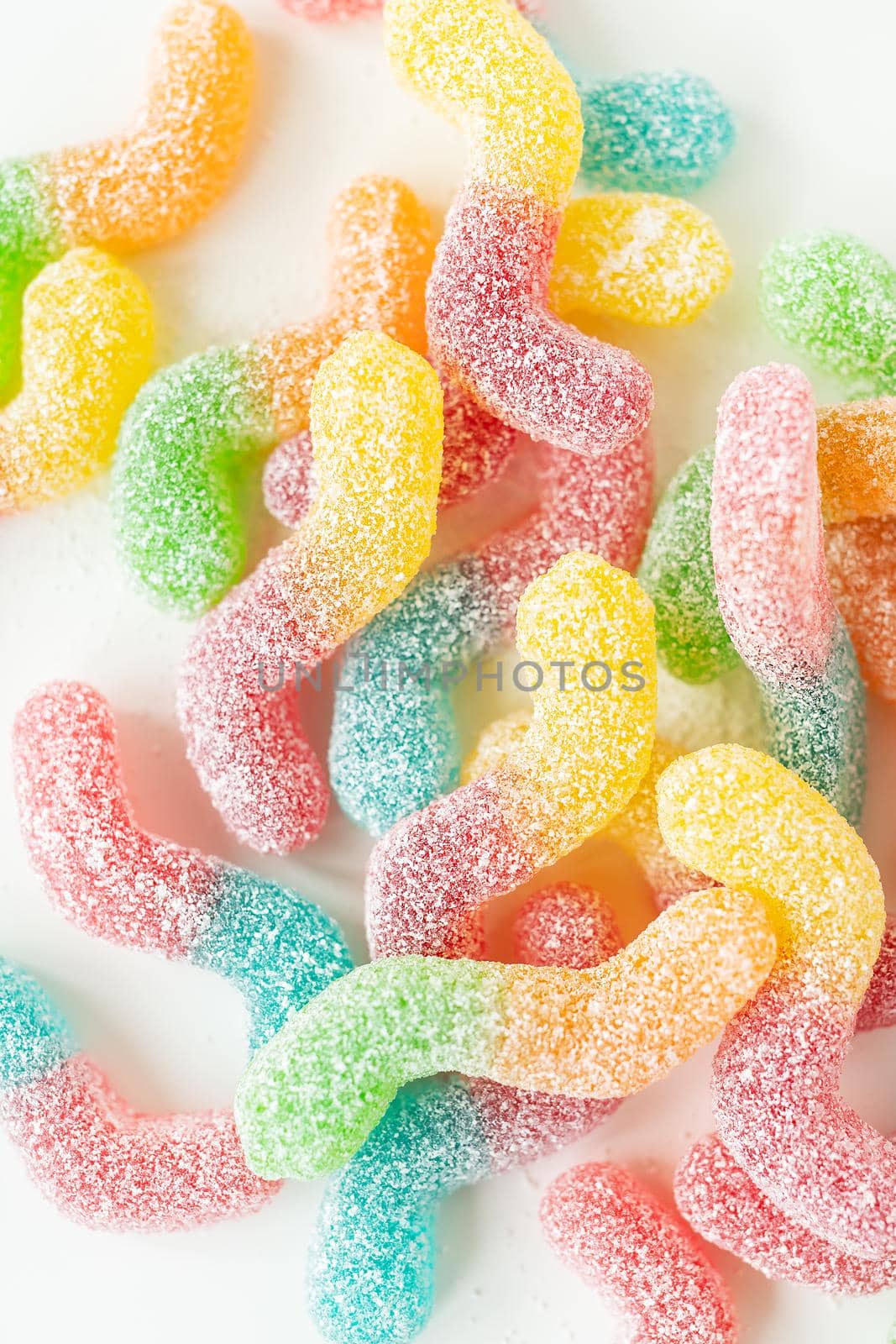 Colorful tasty jelly candies on a white background, top view. Vertical photo. by sfinks