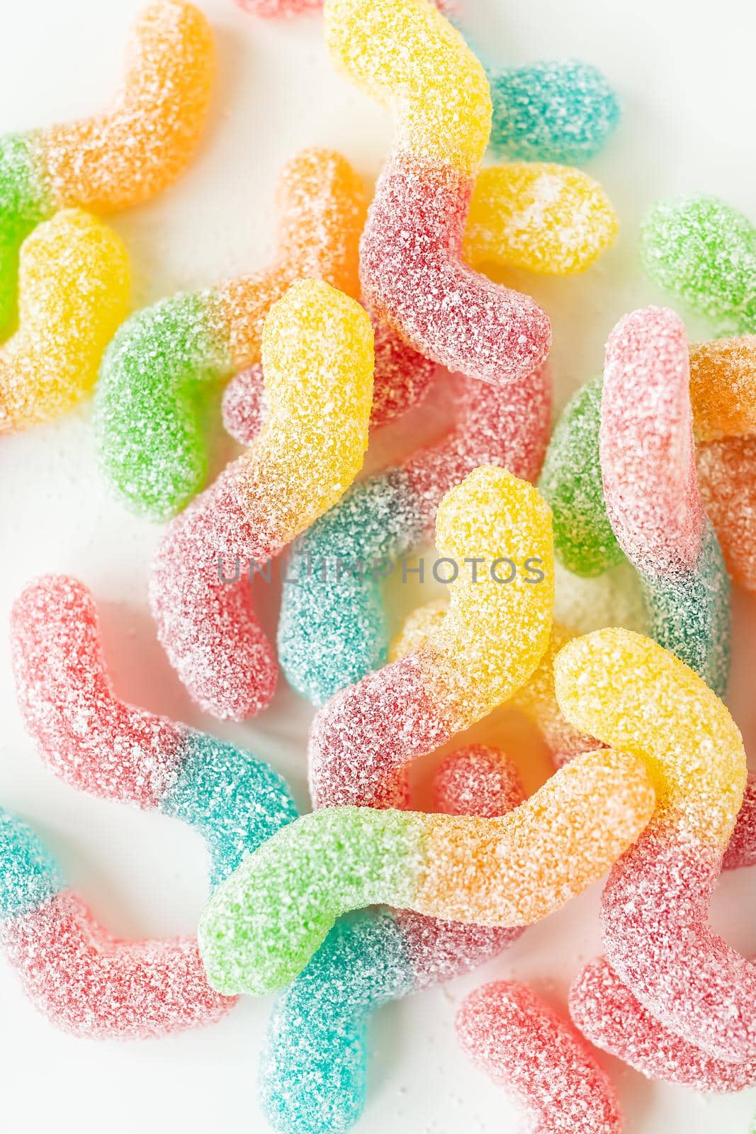 Colorful tasty jelly candies on a white background, top view. Vertical photo