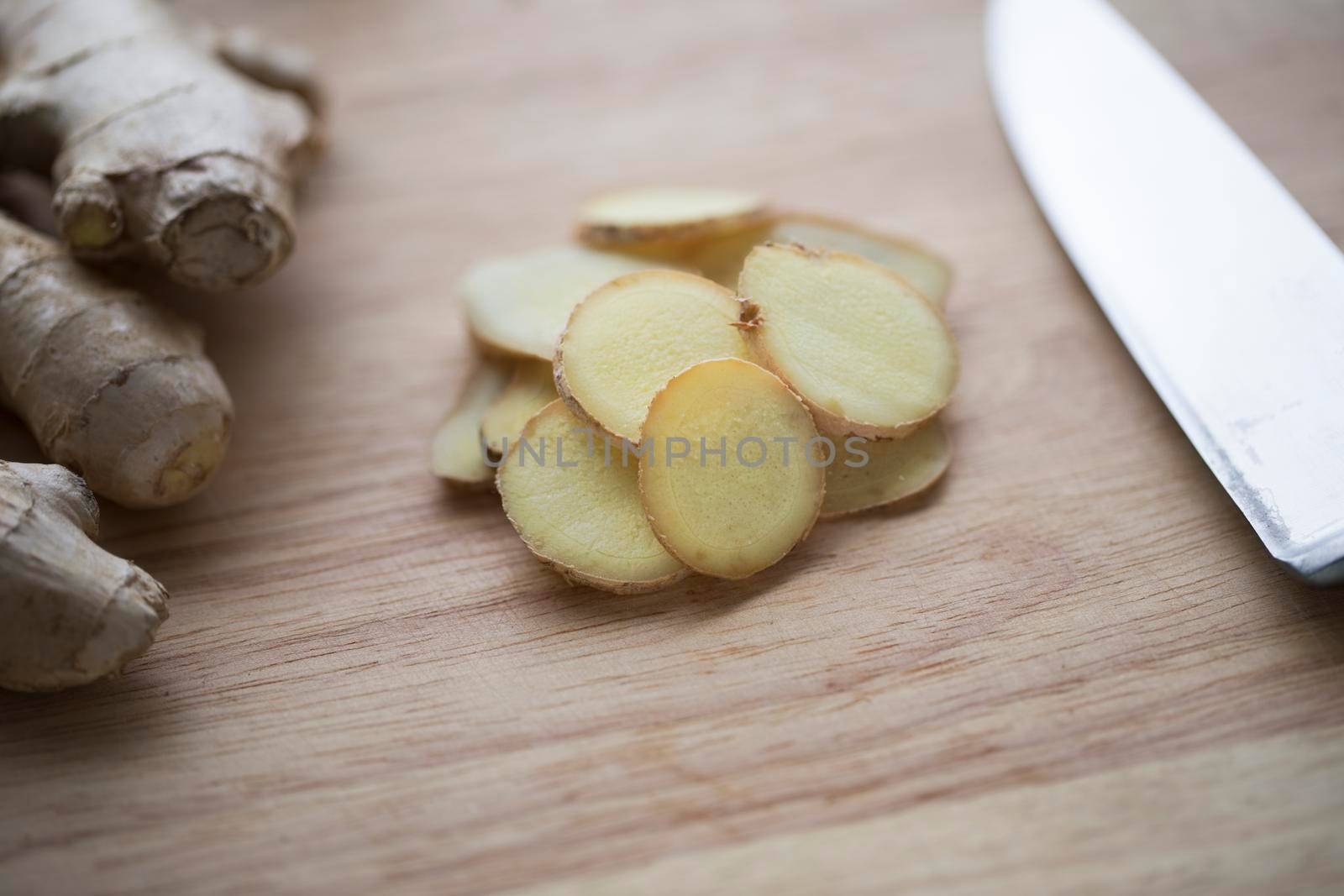 Close up Ginger Root Slices on Cutting Board by charlotteLake
