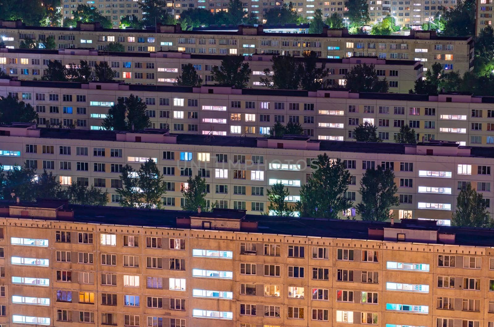 Night colorful windows lights of the high-rise residential building in city sleeping area