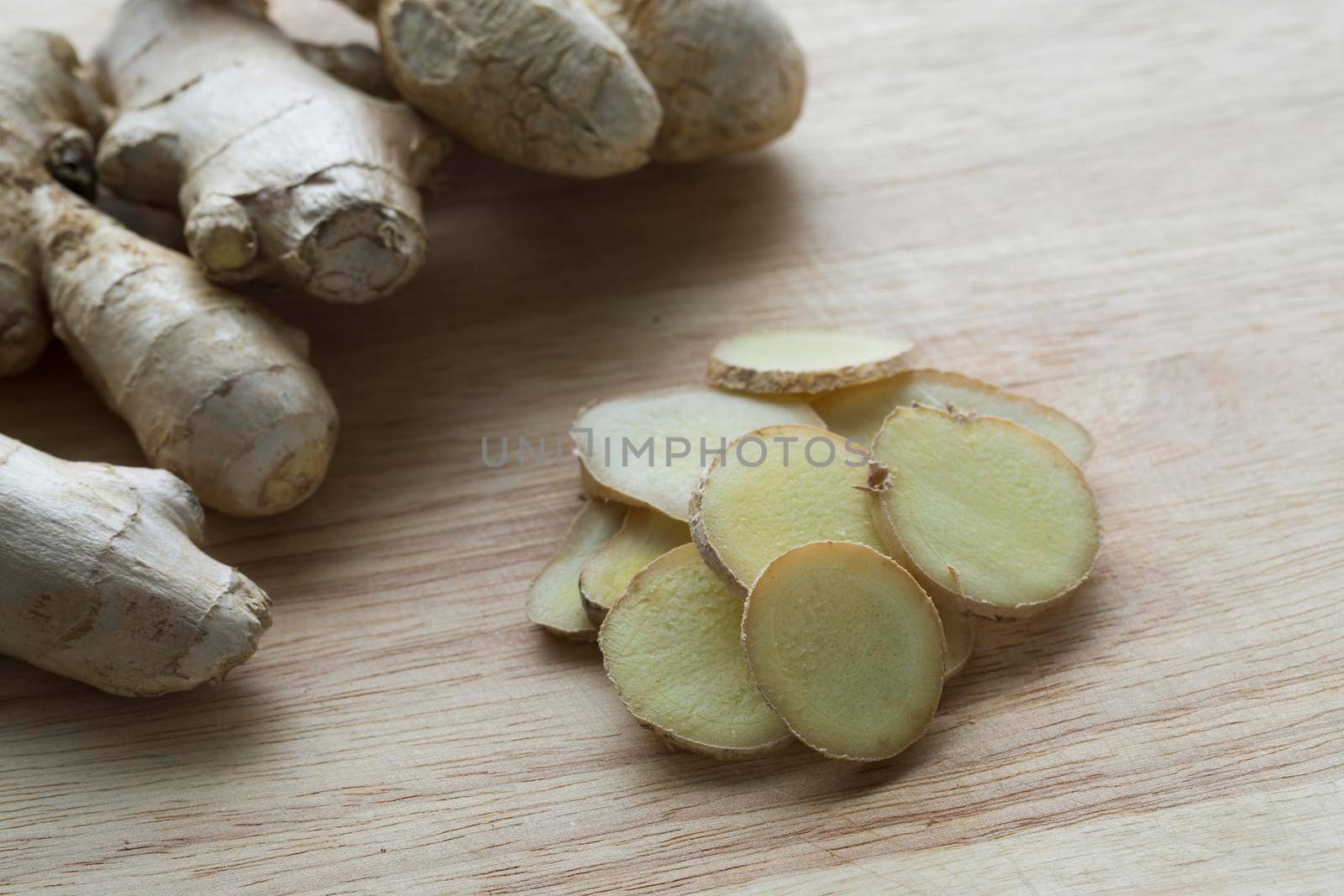 Ginger root and slices on cutting board