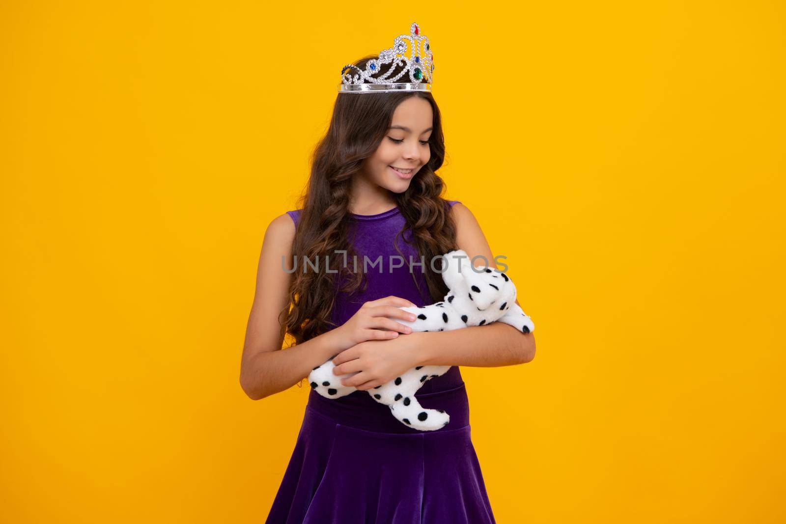 Little queen wearing golden crown. Teenage girl princess holding crown tiara. Prom party, childhood concept. Happy girl face, positive and smiling emotions