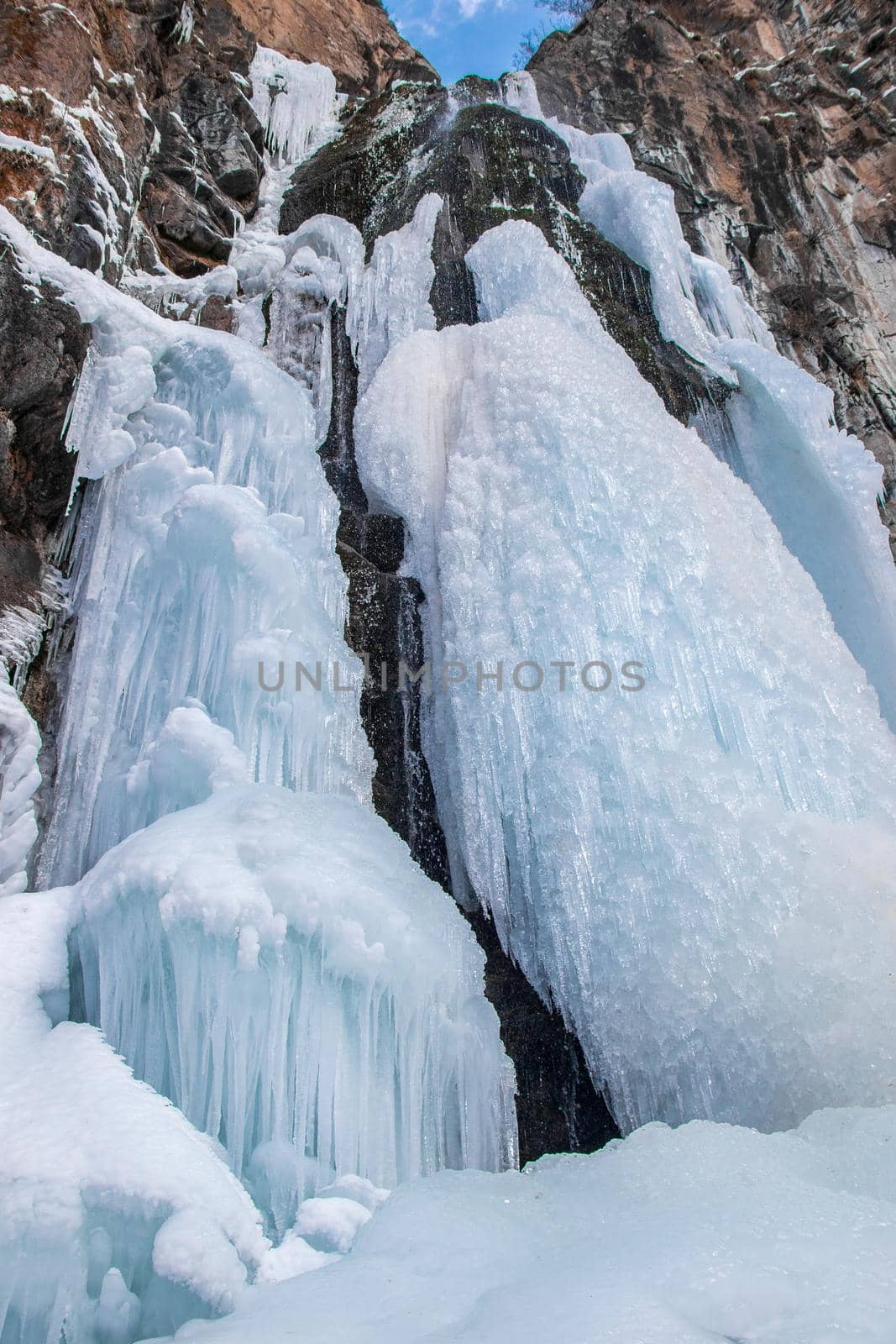 Frozen waterfall in the mountains of the Zailiyskiy Alatau in Central Asia. Winter trip around the outskirts of Almaty.
