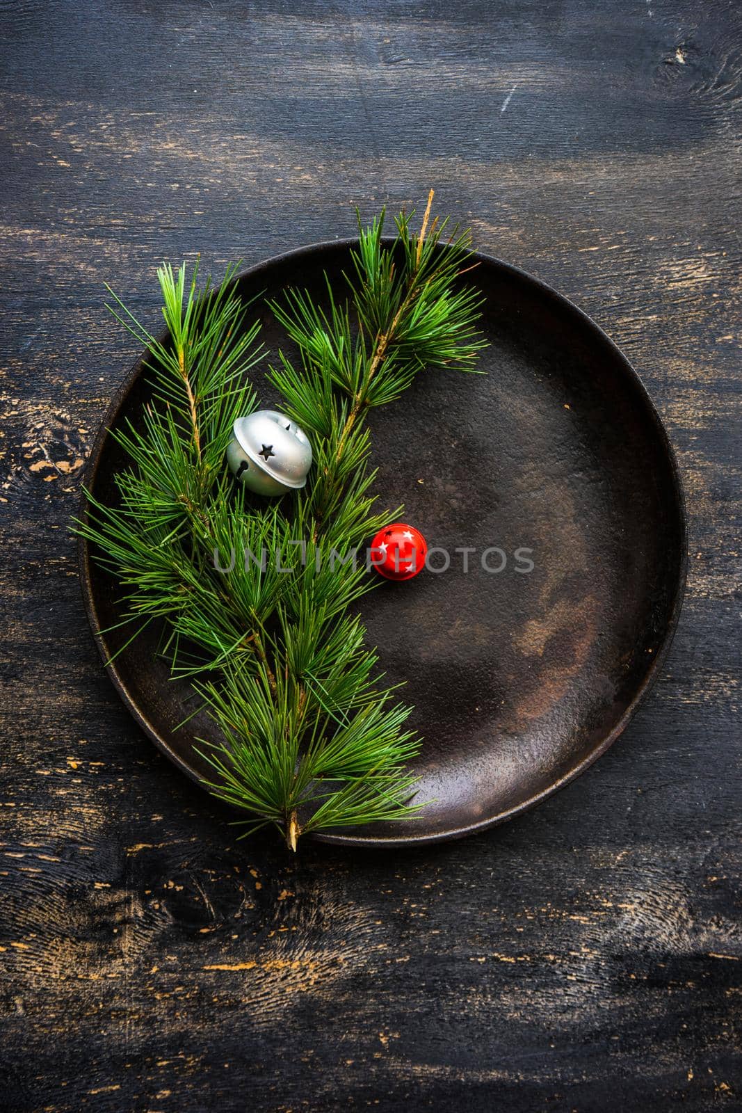 Table setting for festive Christmas dinner on dark wooden table with vintage plates and silverware