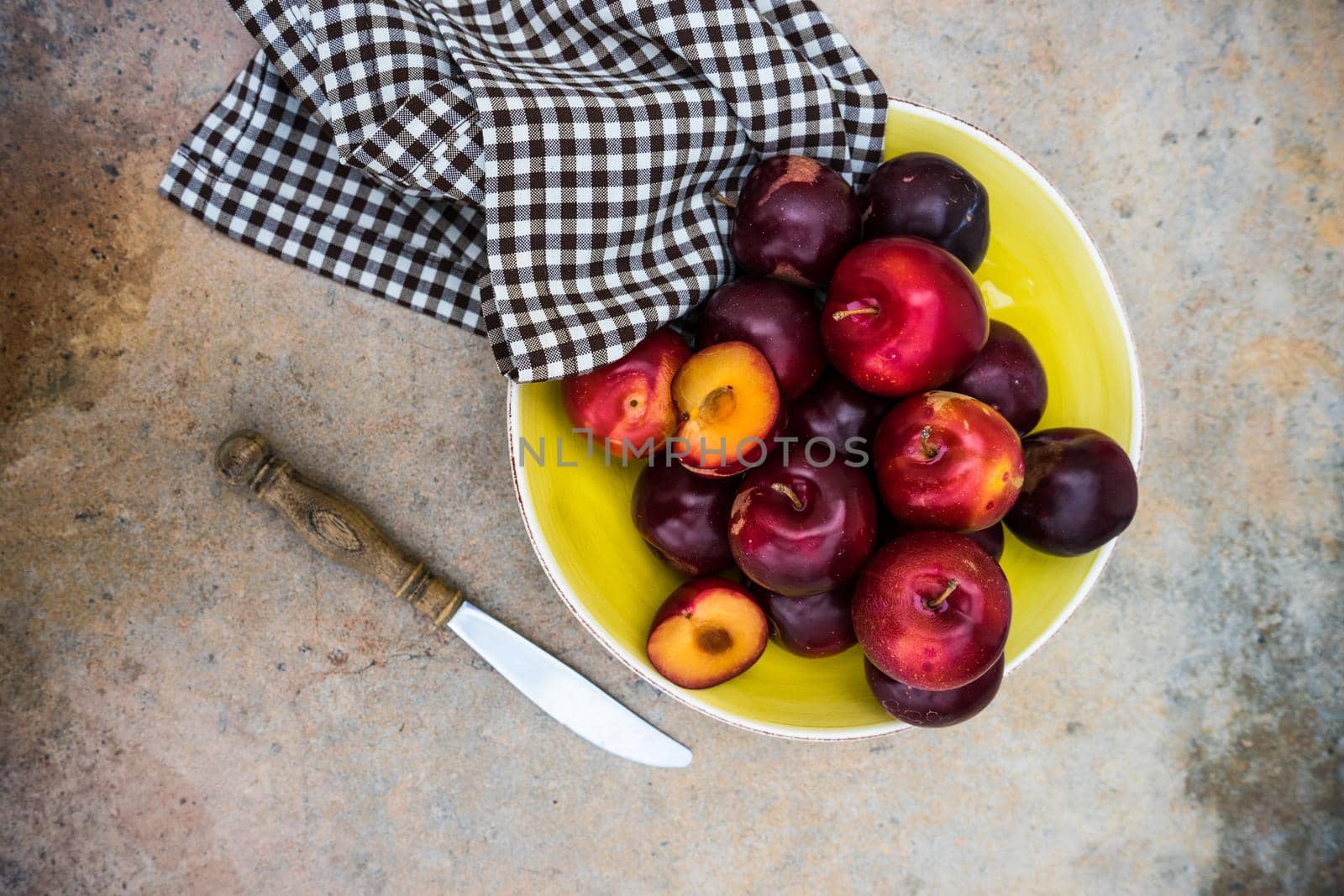 Fresh organic plums  on old rustic wooden table