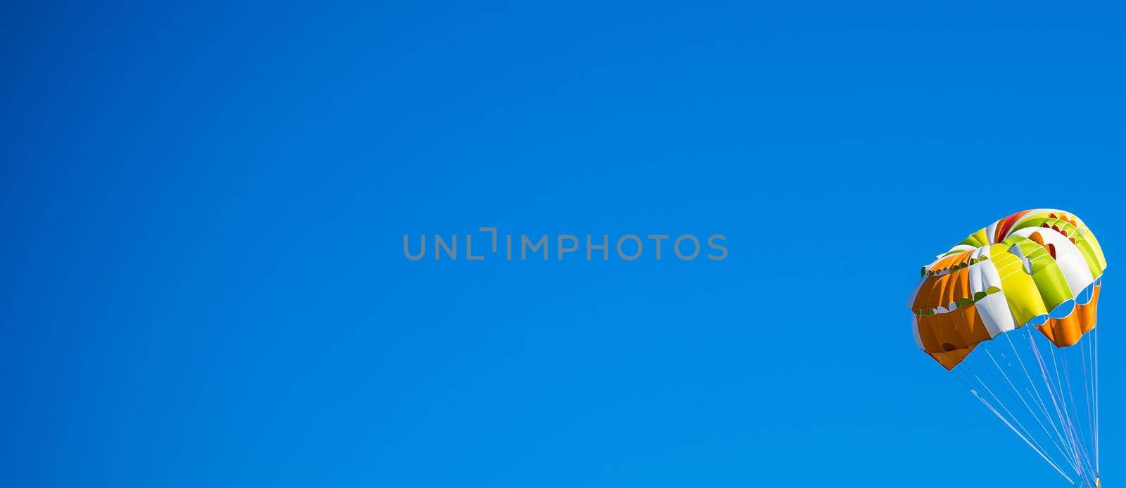 Travel concept with bright paraplane on blue sky background