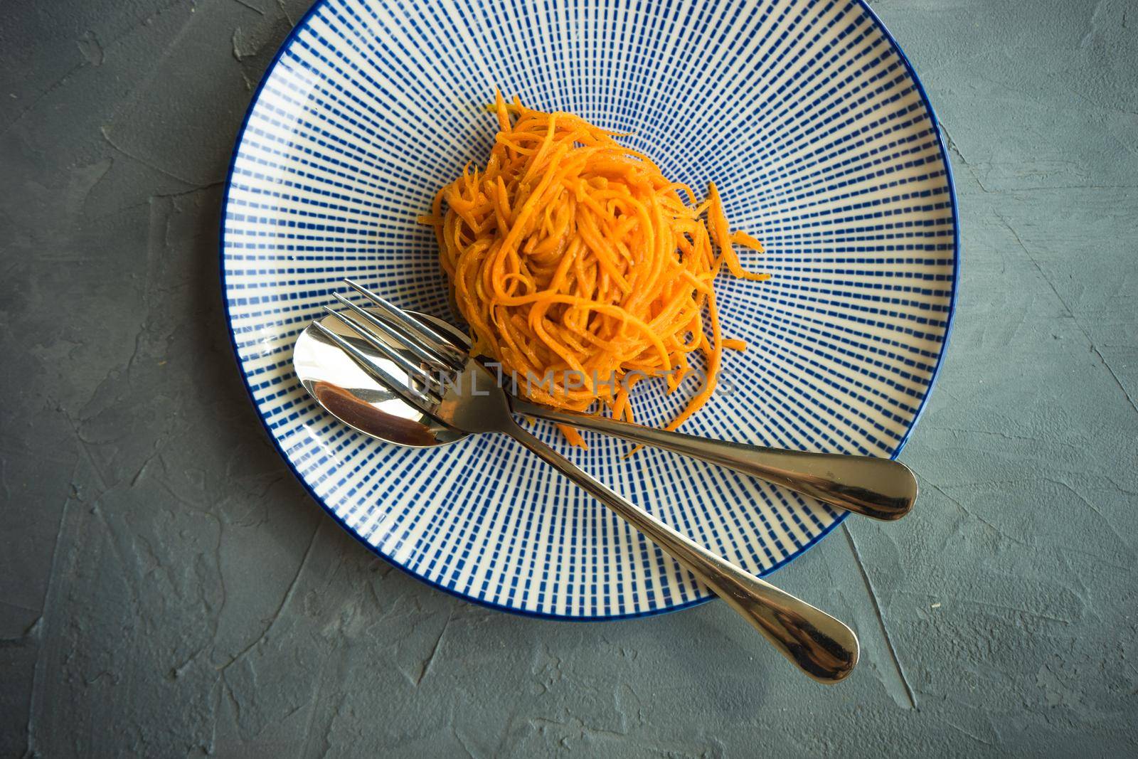 Organic spicy carrot salad on rustic table with copyspace as an organic food concept