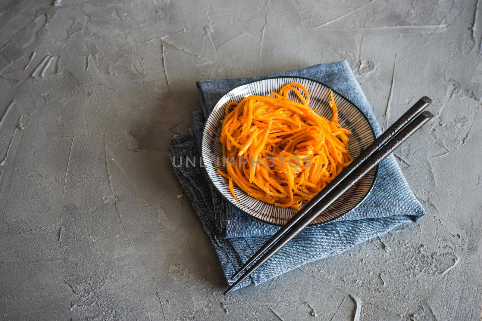 Organic spicy carrot salad on rustic table with copyspace as an organic food concept