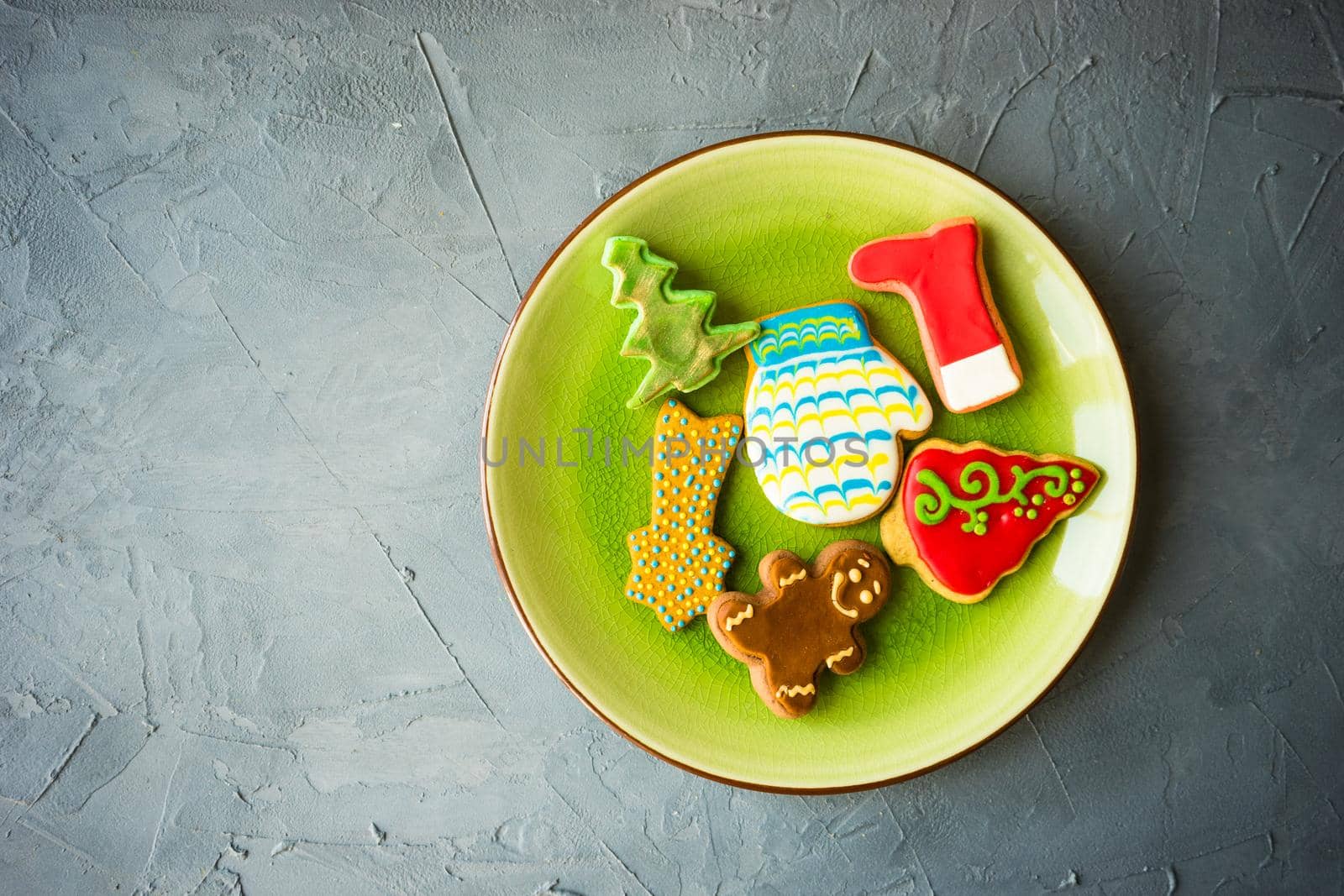 Festive gingerbread cookies for Christmas holiday celebration on ceramic plate on concrete background with copyspace