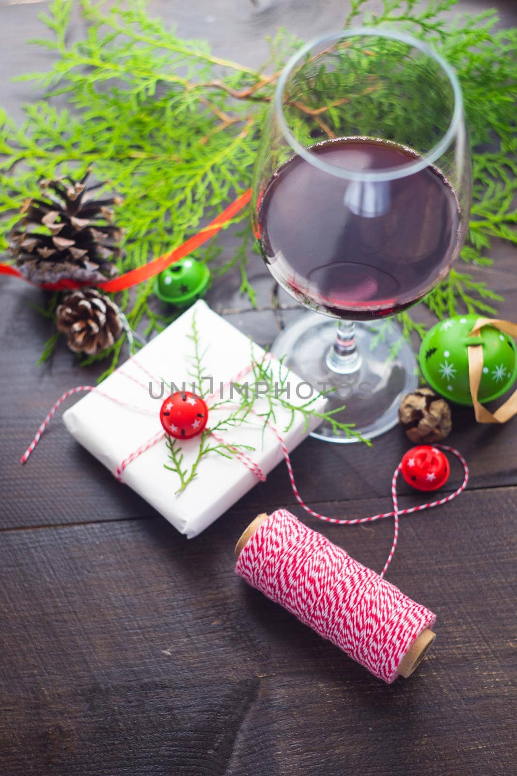 Christmas concept with glas of red wine and gifts on dark wooden table with copyspace