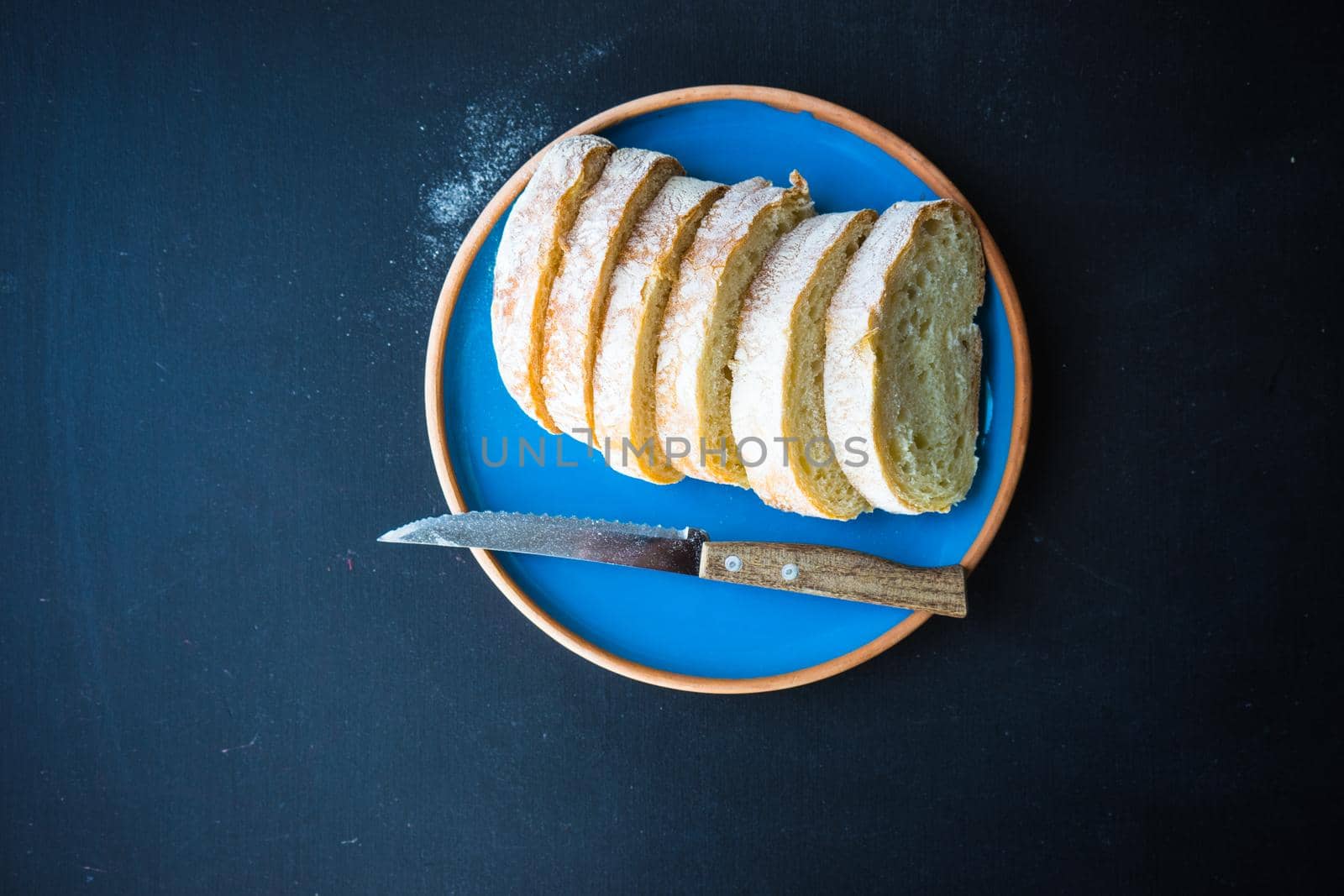 Fresh baked italian bread - ciabatta  on rustic table with napkin