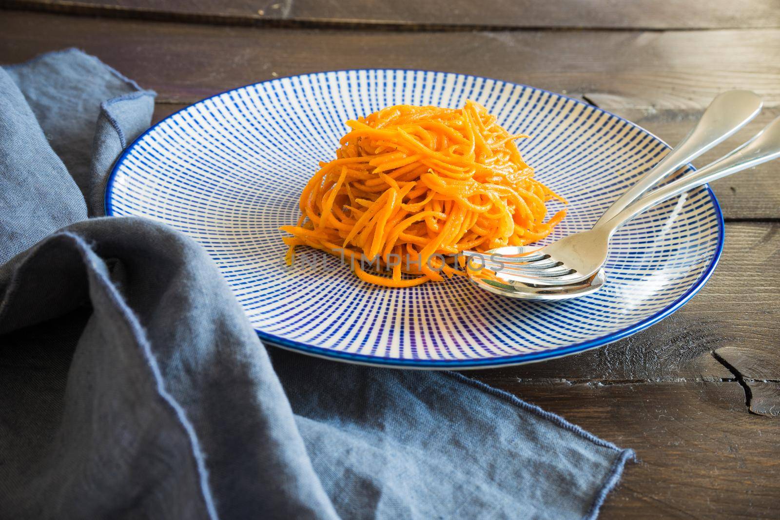 Organic spicy carrot salad on rustic table with copyspace as an organic food concept