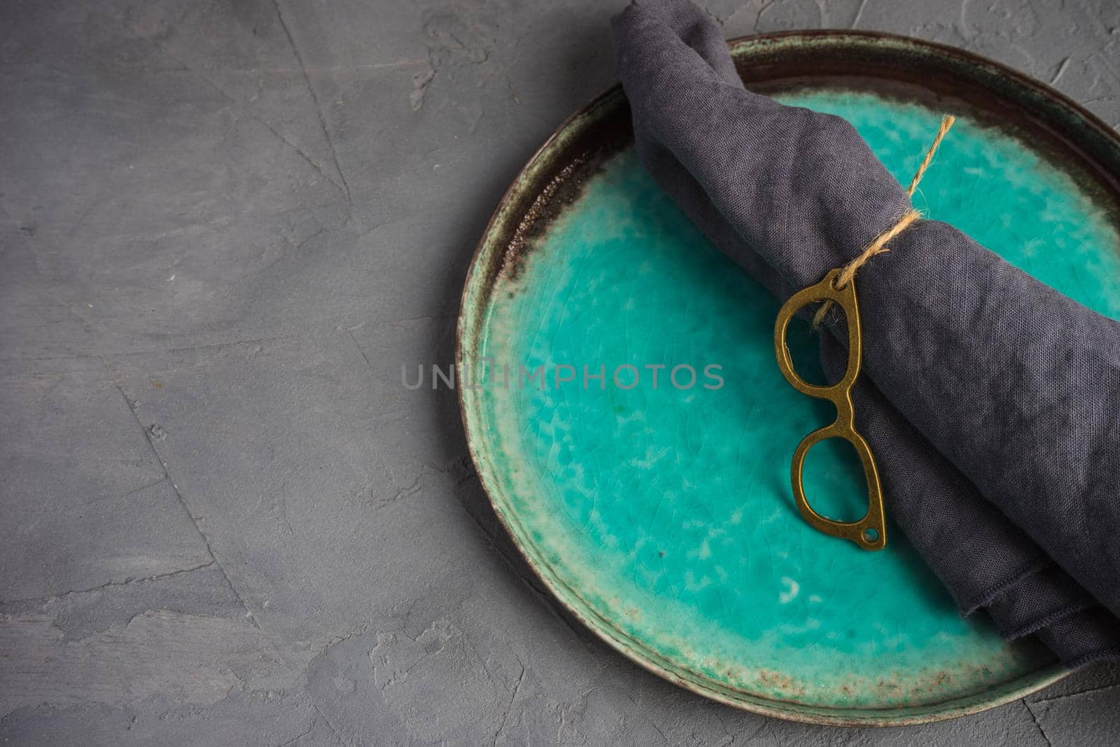 Rustic table setting with vintage tableware  and glasses napkin ring on grey concrete table with copyspace