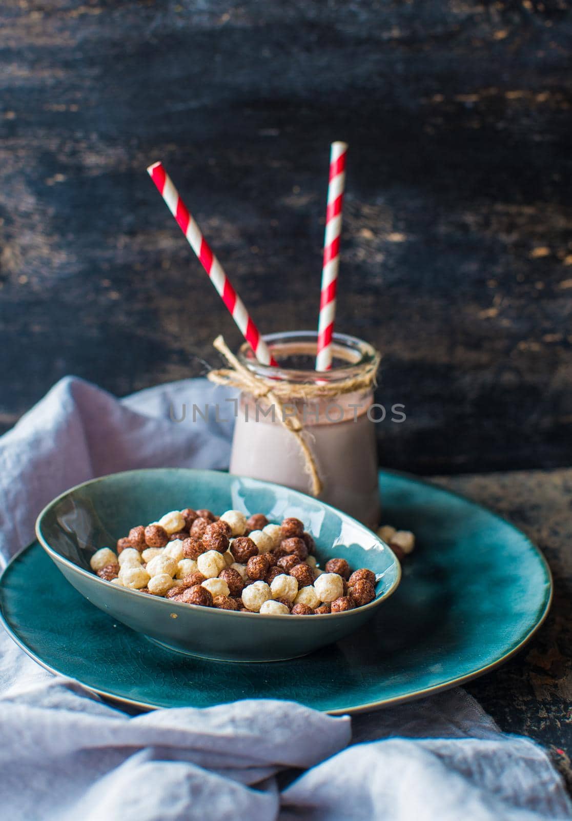 Healthy breakast corn flakes in a bowl and glass of milk on rustic wooden table with copyspace