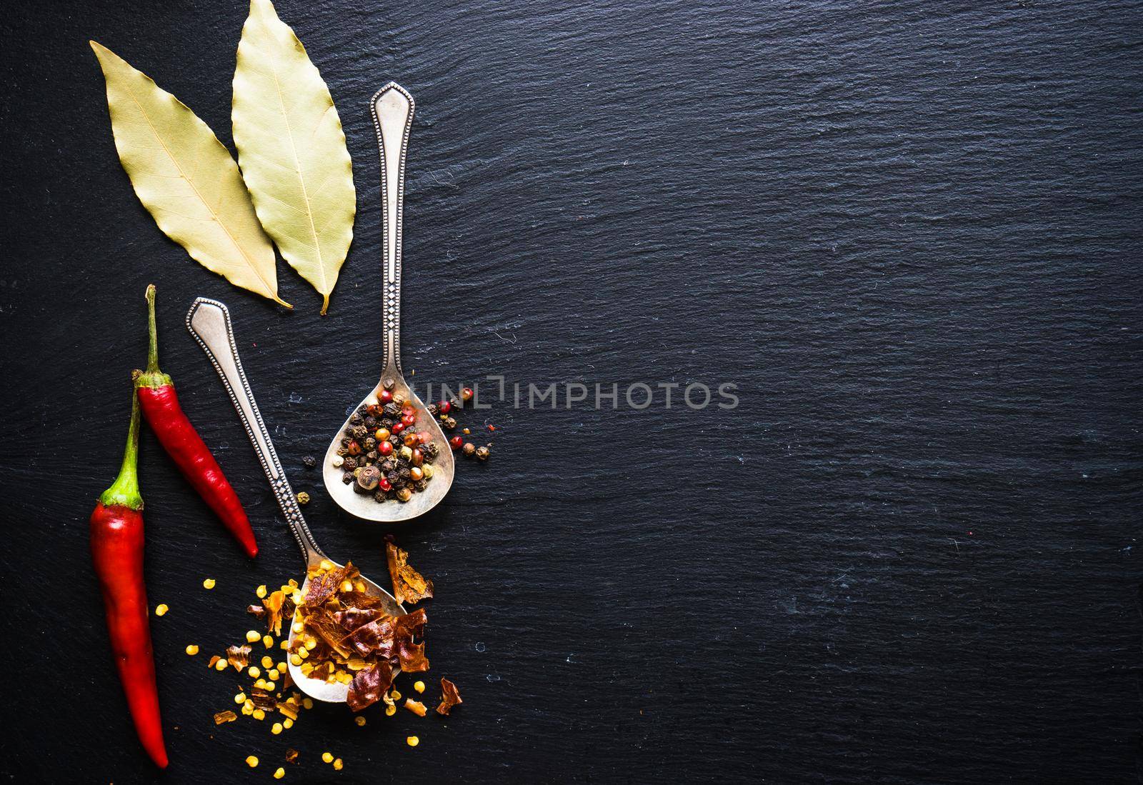Spices withdifferent types of pepper on dark background with copyspace