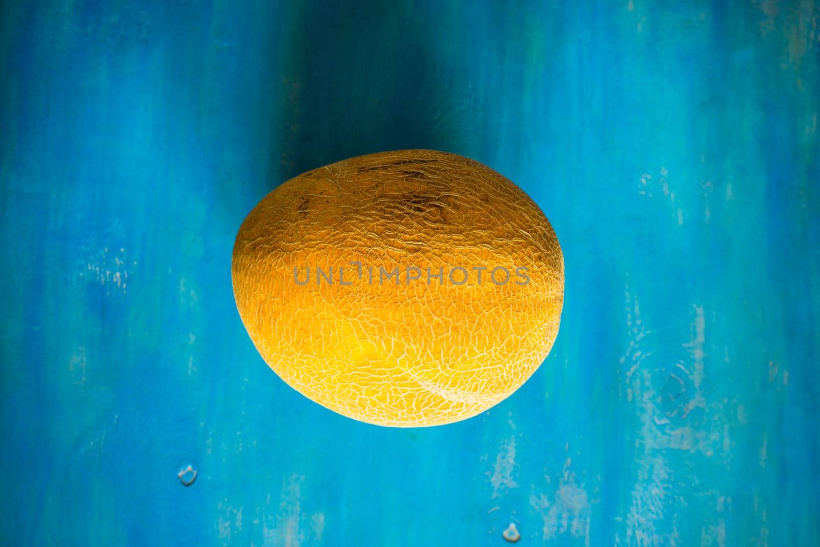 Organic summer melon on bright blue wooden table with copyspace