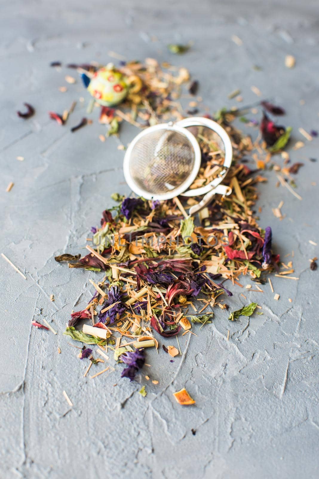 Dry tea leaves with flowersand fruits on wooden background with copyspace as a organic tea concept