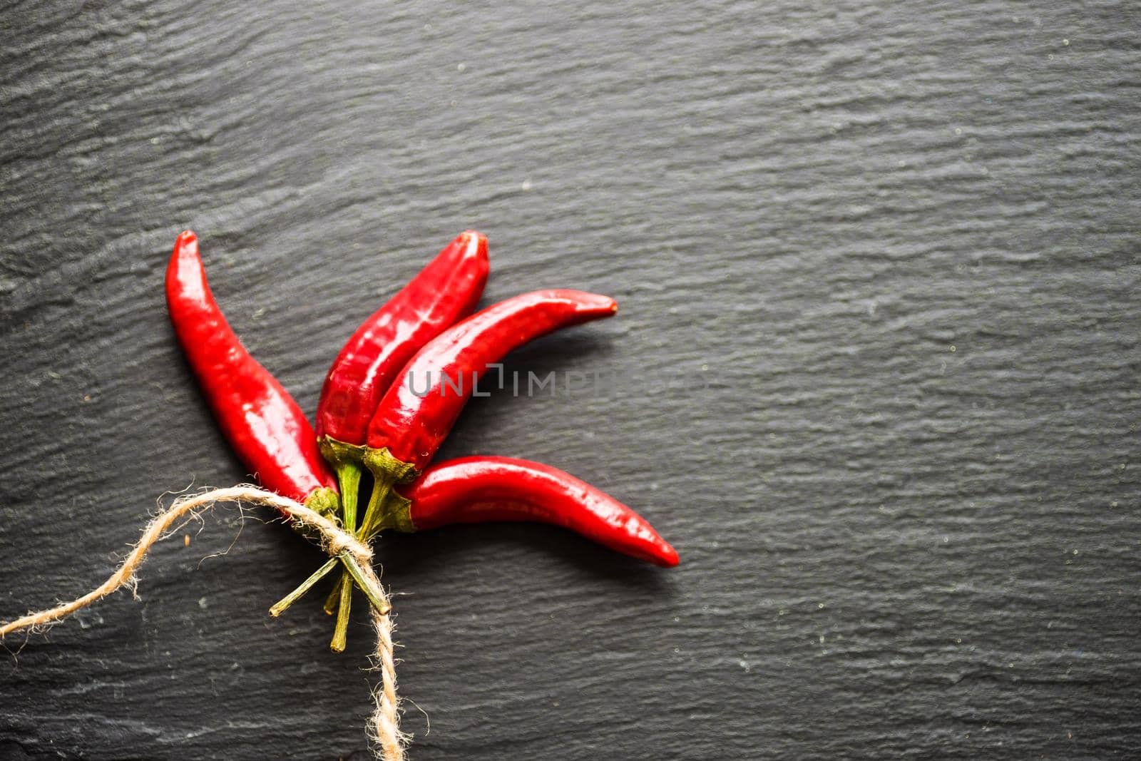 Red hot chilli peppers on dark background with copyspace