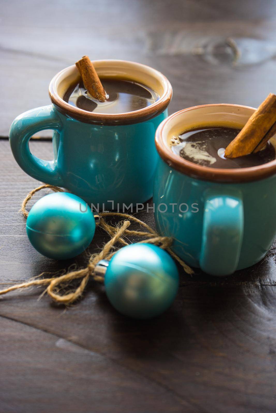 Mug of coffee with spices - cinnamon sticks and anise star with Christmas decor on dark wooden table with copyspace