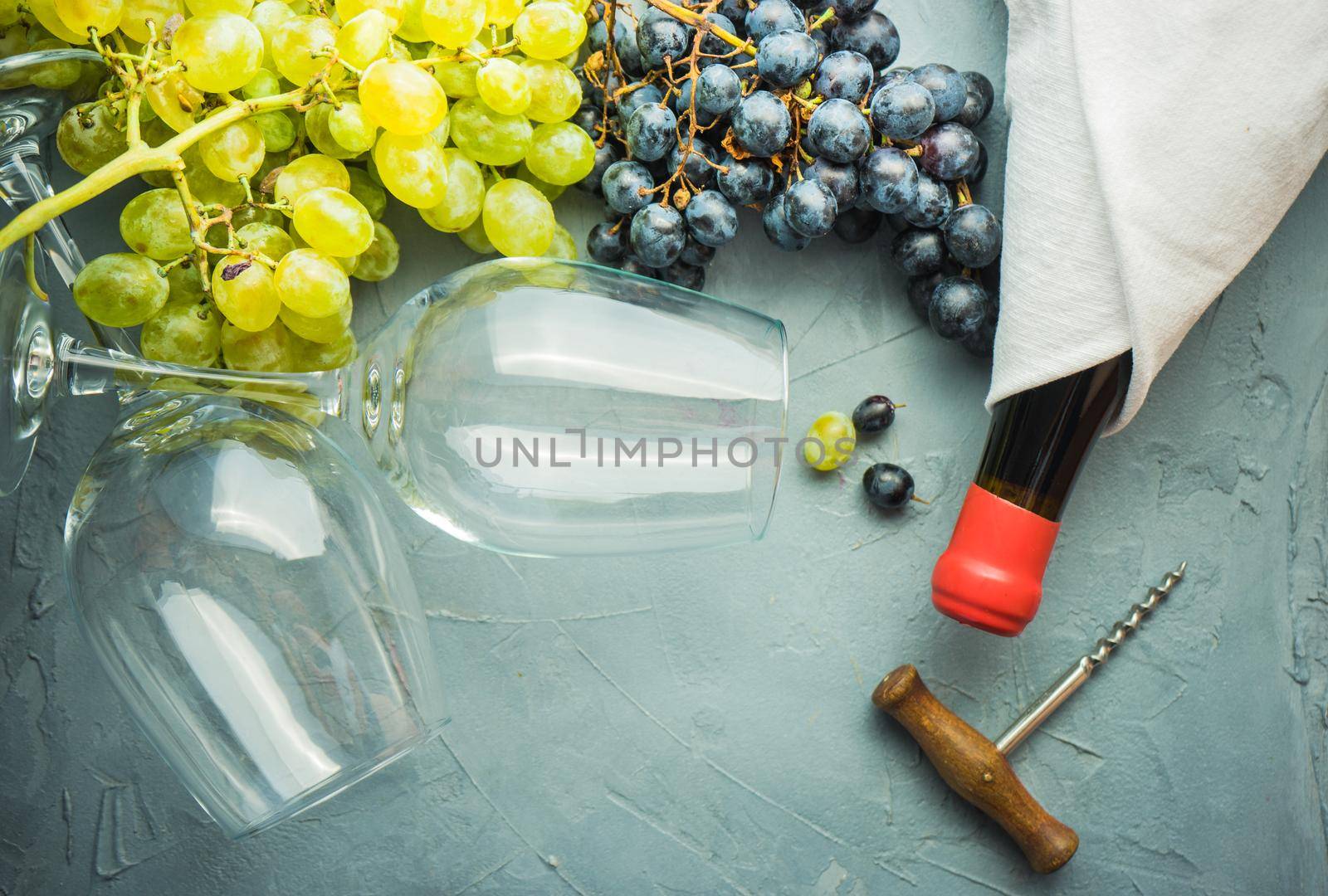 Organic ripe grape and vintage corkscrew on rustic background as a wine concept