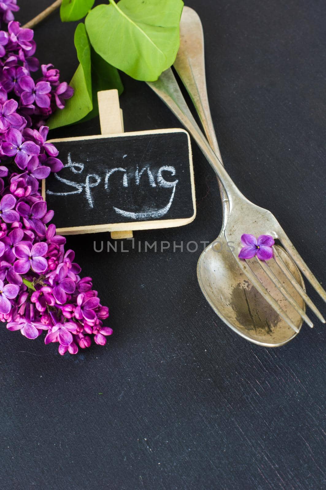 Spring table setting with bright lilac flowers on rustic background with copyspace