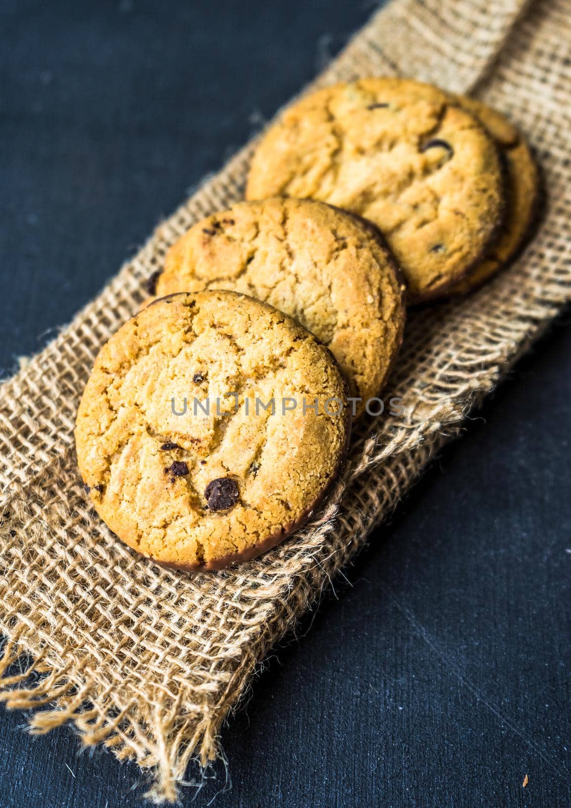 Flat lay of chocolate cookies on burlap napkin with copyspace