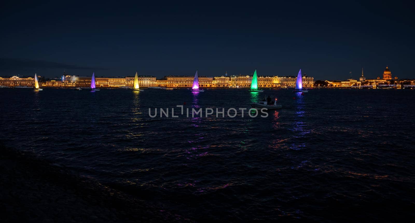 Russia, St. Petersburg, 07 August 2022: A few sailboats with sails illuminated in the tricolor of Russia go in the city center at the celebration of the opening of the sailing week, sightseeing . High quality photo