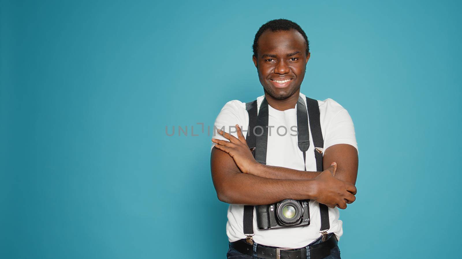 Portrait of model with photography hobby posing on camera, using professional equipment to capture pictures. Photographer sitting with crossed arms to take photos in studio, creative art.