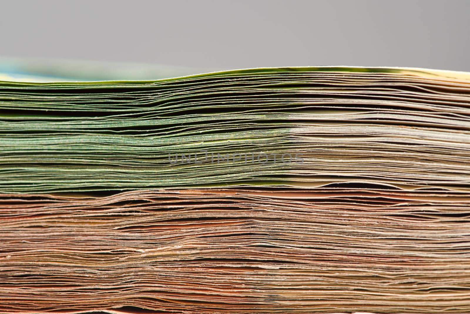 Close-up of a stack of paper bills, side view. Euro banknotes stacked on top of each other. Big pile of money